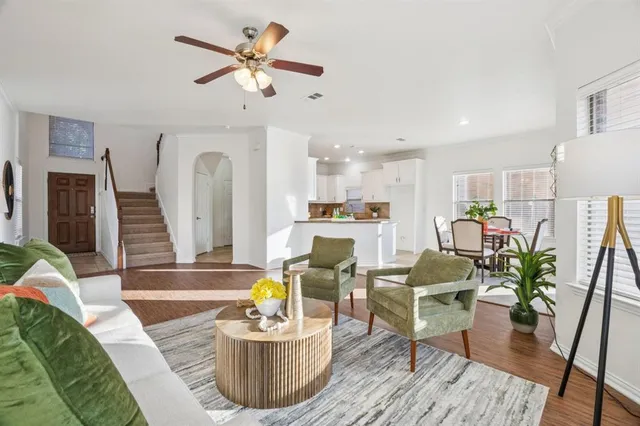 a living room with furniture kitchen view and a chandelier