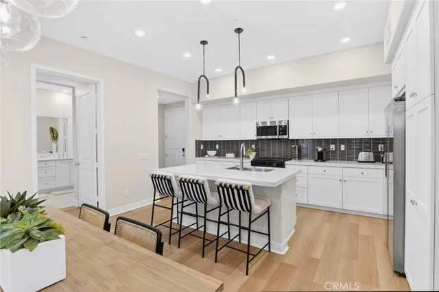 a living room with furniture kitchen view and a flat screen tv