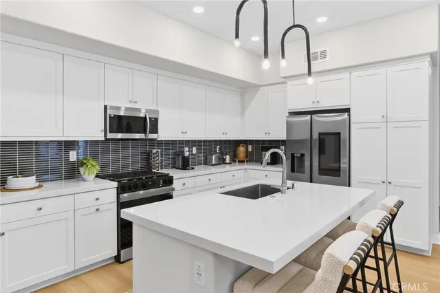 a kitchen with white cabinets and stainless steel appliances
