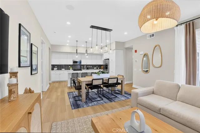 a kitchen with kitchen island stainless steel appliances a dining table and chairs