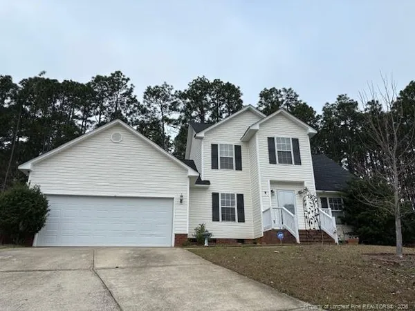 a view of white house with a yard and garage