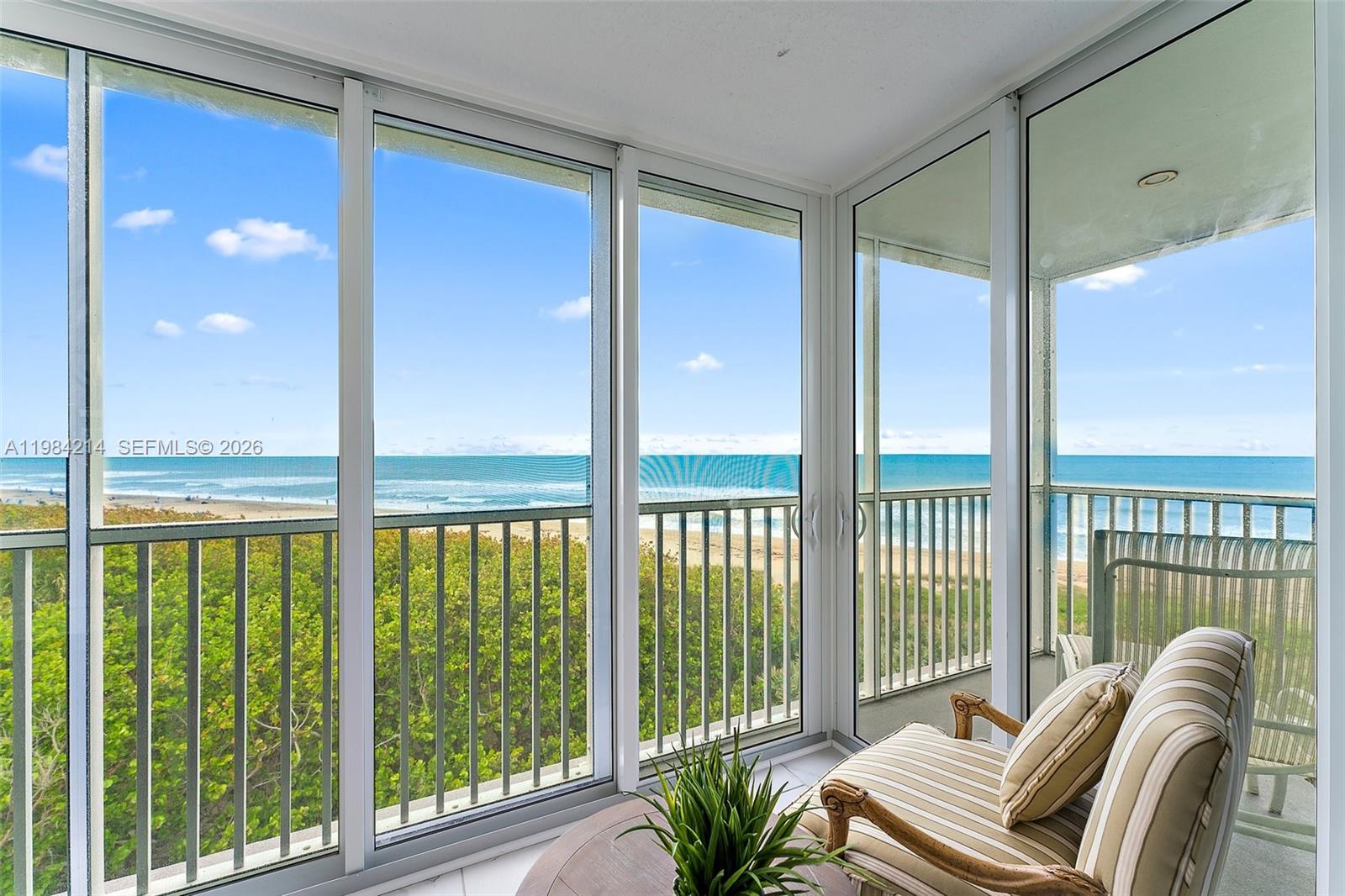 669 Northeast Plantation Road, Unit 406 Stuart, FL 34996 - Photo 2 of 41 a balcony view with a couch and large windows
