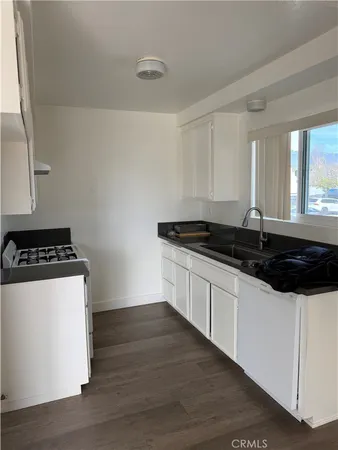 a kitchen with granite countertop a sink and a stove