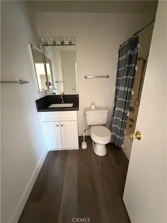 a bathroom with a granite countertop sink toilet and mirror