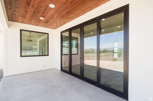 3322 250 S Street Vernal, UT 84078 - Photo 32 of 37 Covered patio featuring a wood-finish ceiling with recessed lighting, a multi-panel sliding glass door, and a large fixed window