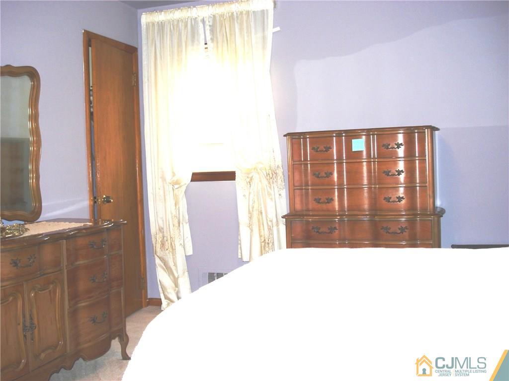 10 Morningside Road Colonia, NJ 07067 - Photo 9 of 18 a bedroom with a bed and a flat tv screen next to a window