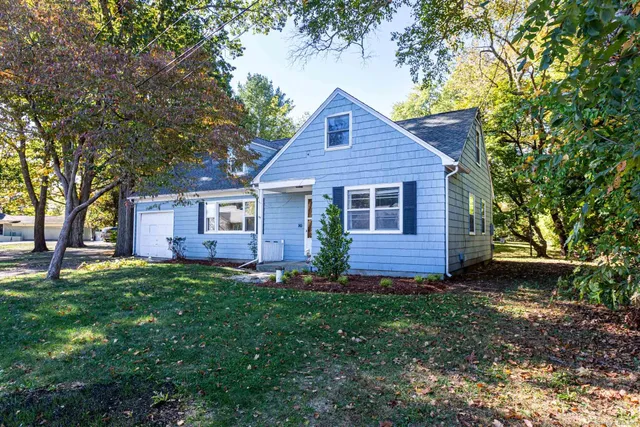 a view of a yard in front of a house with large tree