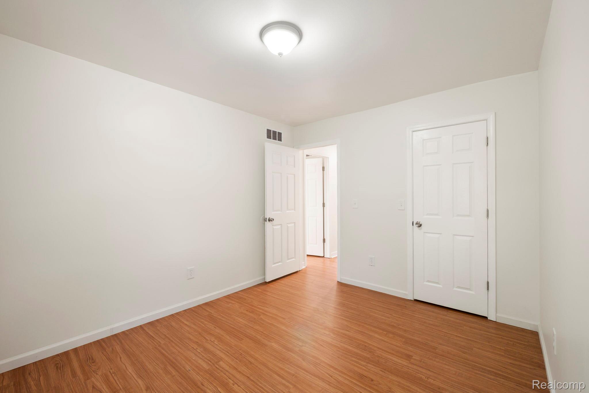 76565 McFadden Road Armada, MI 48005 - Photo 36 of 95 Wood-finish flooring, white walls, white trim, and a ceiling-mounted light fixture