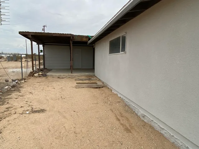 a backyard of a house with table and chairs