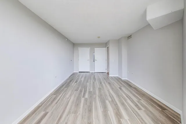 a view of empty room with wooden floor