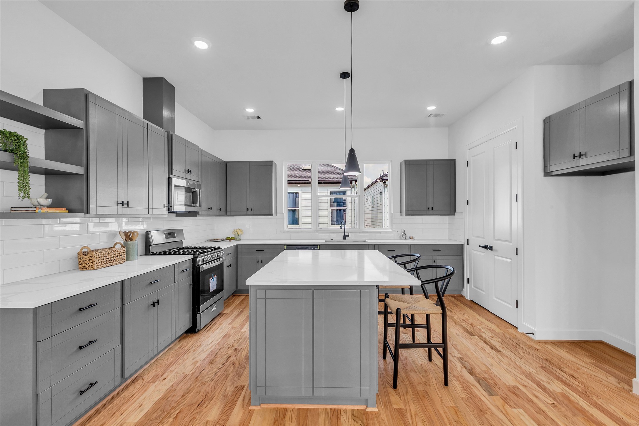 9426 Campbell Road, Unit A Houston, TX 77080 - Photo 6 of 26 a kitchen with stainless steel appliances kitchen island granite countertop a stove a sink a refrigerator and white cabinets with wooden floor