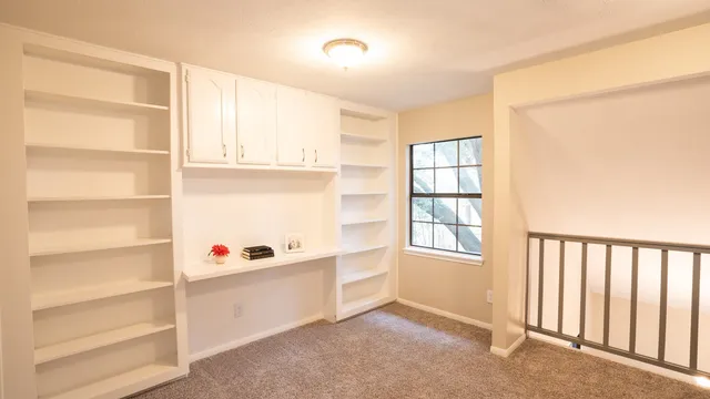 a room with a closet and wooden shelves