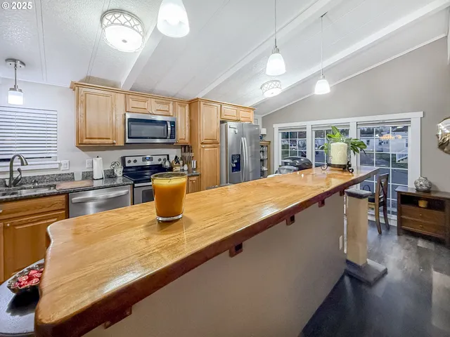 a kitchen with stainless steel appliances granite countertop sink stove top oven and cabinets