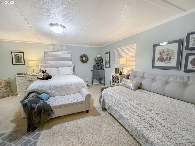 a spacious bedroom with two beds and painting on the wall