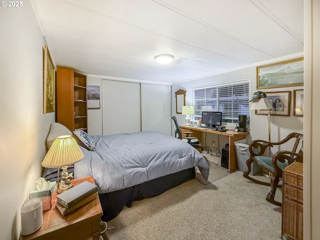 a bedroom with bed a table and chair