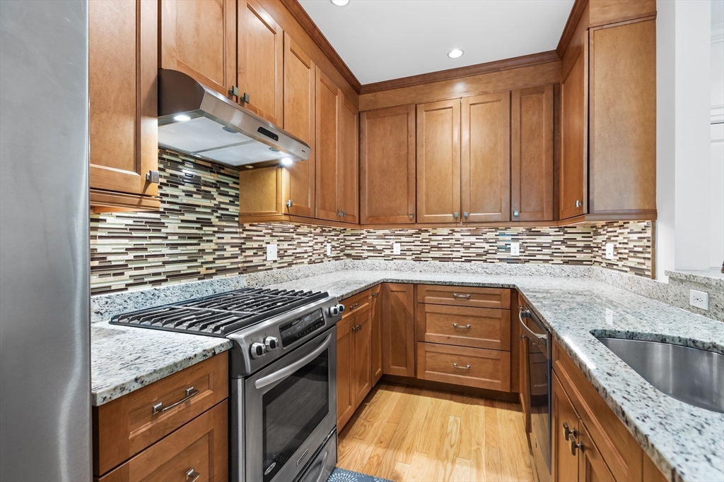 39 Taylor Drive, Unit 2006 Reading, MA 01867 - Photo 13 of 36 a kitchen with stainless steel appliances granite countertop a sink stove and cabinets