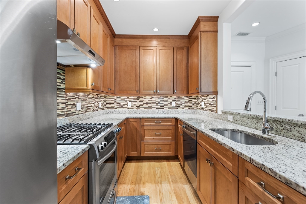 39 Taylor Drive, Unit 2006 Reading, MA 01867 - Photo 14 of 36 a kitchen with granite countertop a sink a counter space and stainless steel appliances