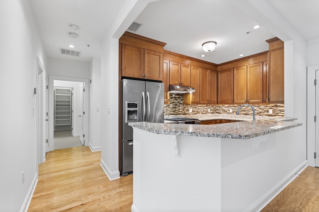 39 Taylor Drive, Unit 2006 Reading, MA 01867 - Photo 19 of 36 a kitchen with stainless steel appliances granite countertop a sink and a refrigerator