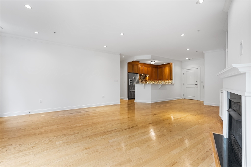 39 Taylor Drive, Unit 2006 Reading, MA 01867 - Photo 20 of 36 an empty room with a fireplace and a chandelier