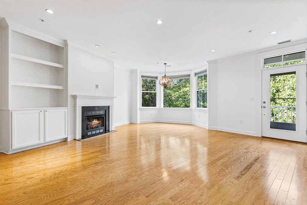 39 Taylor Drive, Unit 2006 Reading, MA 01867 - Photo 9 of 36 a view of empty room with wooden floor and fireplace