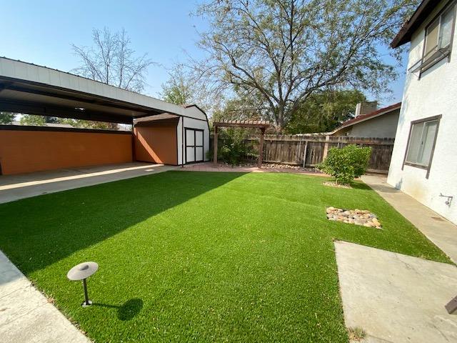 745 Haliburton Way Coalinga, CA 93210 - Photo 29 of 35 a view of a backyard with table and chairs and potted plants
