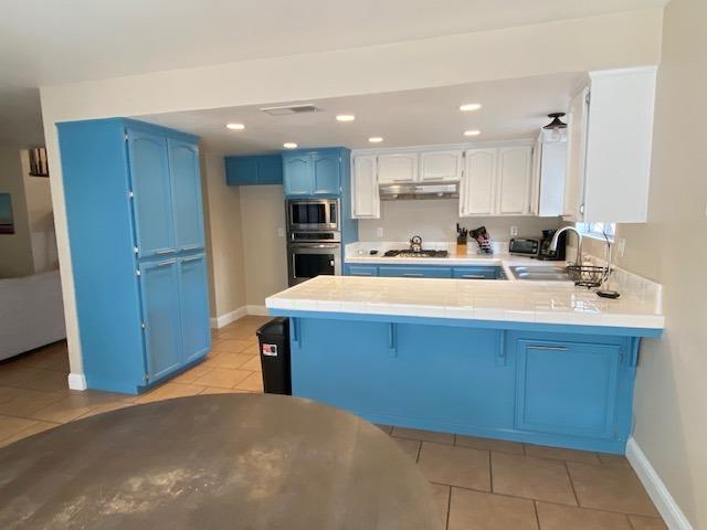 745 Haliburton Way Coalinga, CA 93210 - Photo 9 of 35 a kitchen with kitchen island sink refrigerator and cabinets