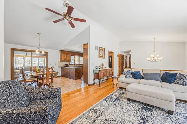 a living room with furniture kitchen view and a large window