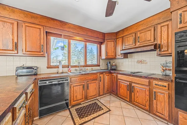a kitchen with stainless steel appliances granite countertop a stove sink and cabinets
