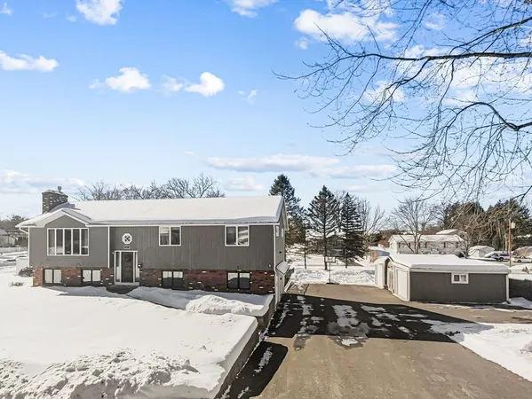 a view of a white house with a yard covered in snow