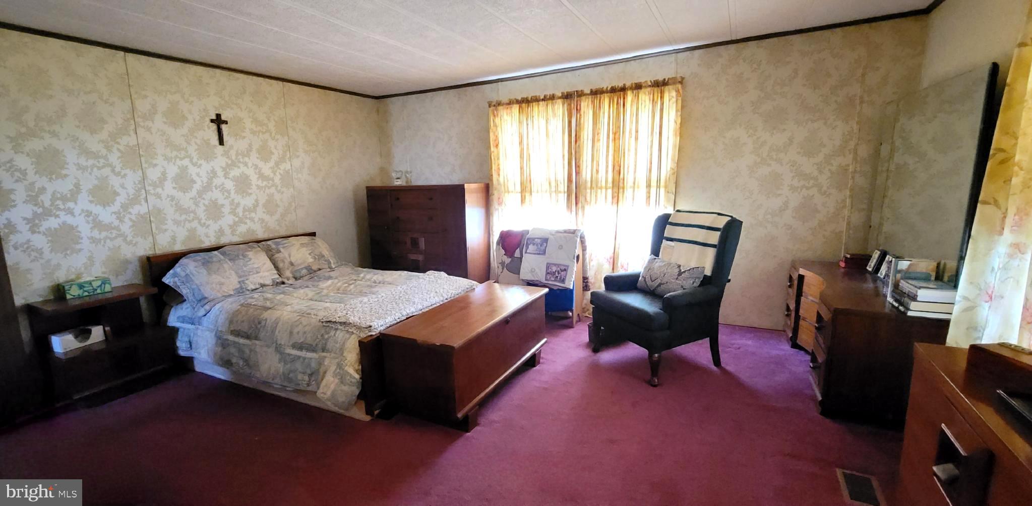 311 John Alden Drive Buena, NJ 08310 - Photo 16 of 35 a bedroom with a bed chairs and a potted plant