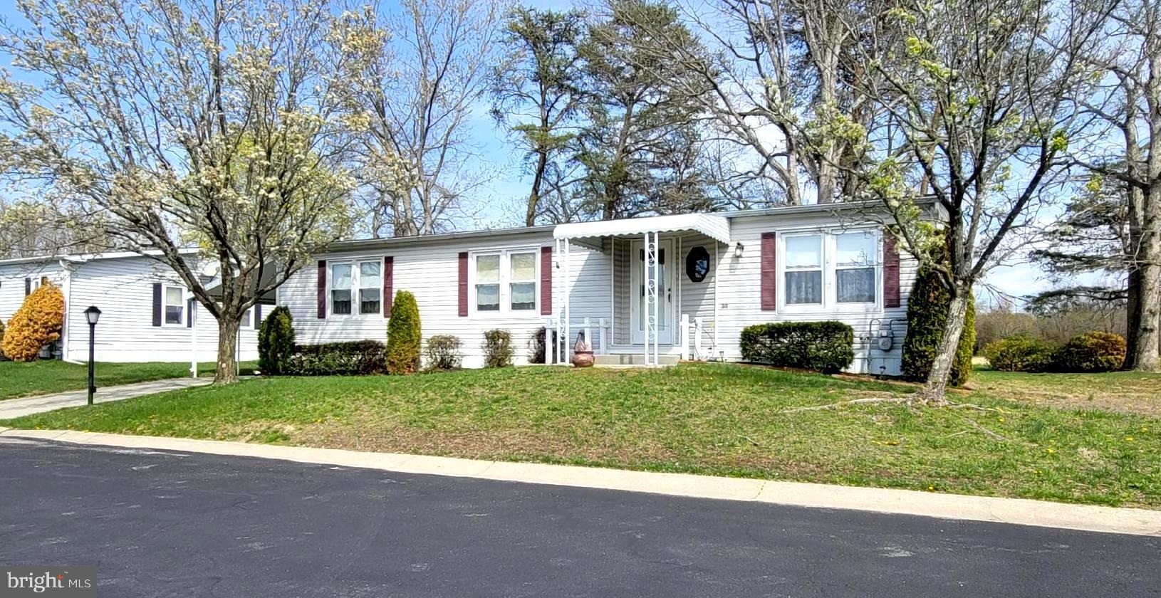 311 John Alden Drive Buena, NJ 08310 - Photo 2 of 35 a front view of a house with a garden and trees