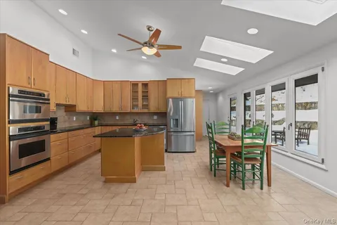 a kitchen with a table chairs microwave and refrigerator