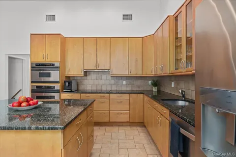 a kitchen with stainless steel appliances granite countertop a sink stove and cabinets