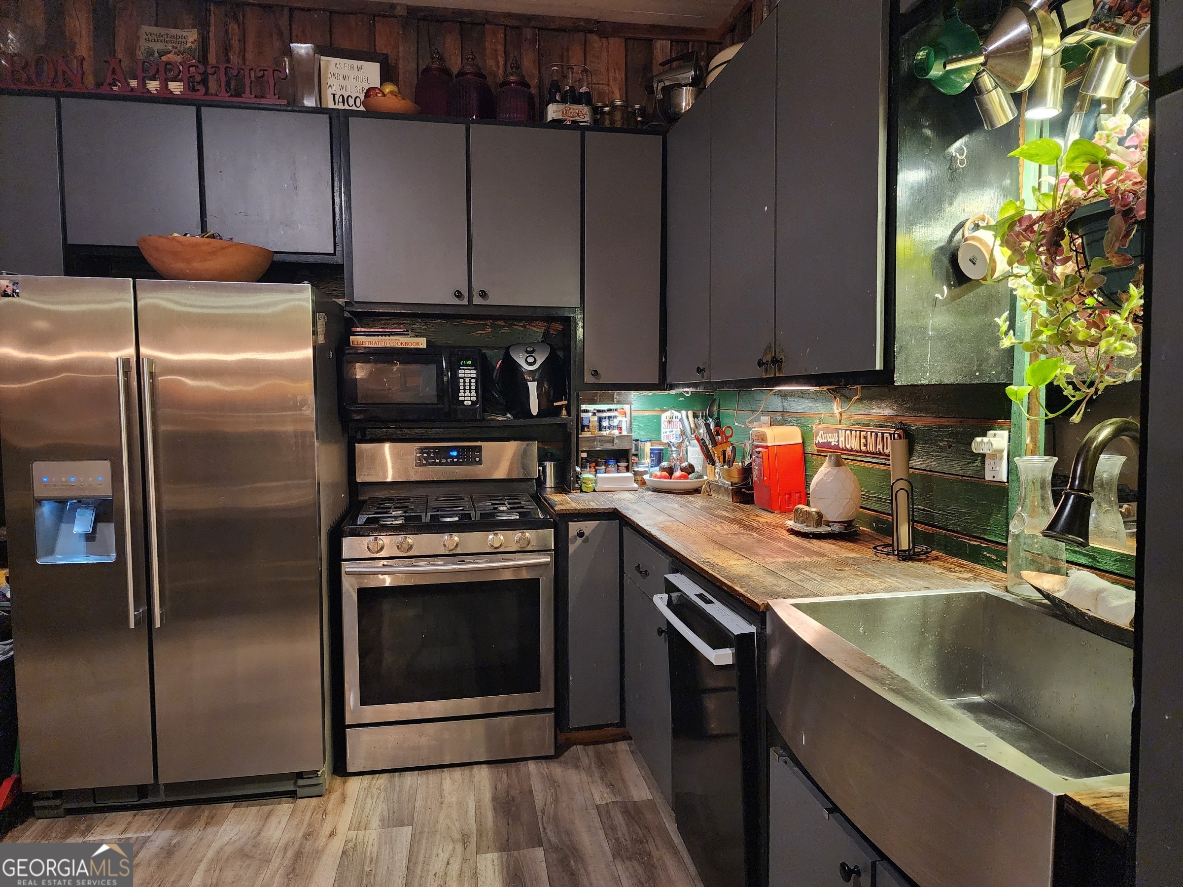 260 Old Copelan Road Southeast Eatonton, GA 31024 - Photo 14 of 88 a kitchen with stainless steel appliances granite countertop a refrigerator a sink a stove and a counter with wooden floor