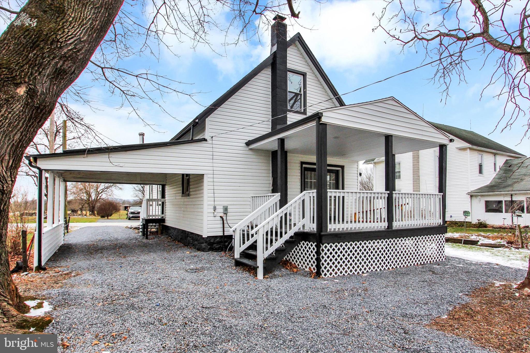 a view of a house with a wooden deck and furniture