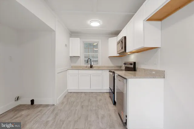 a kitchen with cabinets a sink and appliances