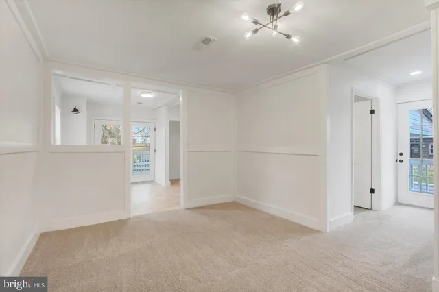 an empty room with an entryway and fan