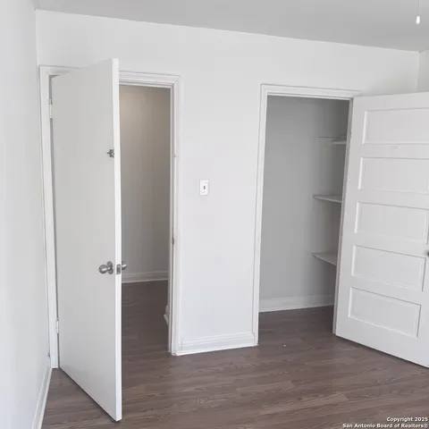 an empty room with wooden floor and closet