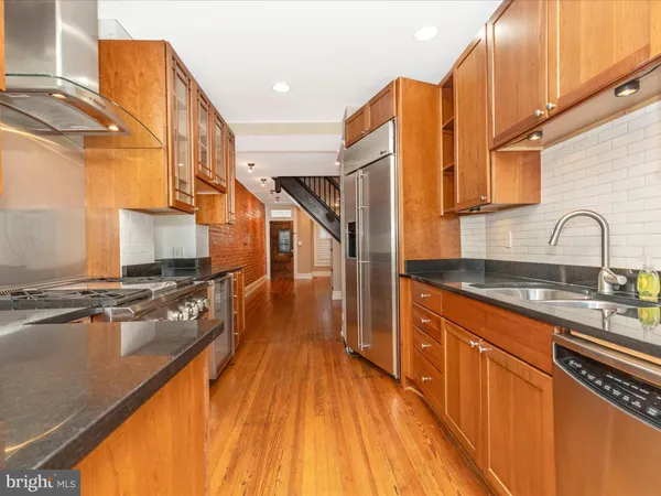 a kitchen with stainless steel appliances granite countertop a refrigerator and a sink