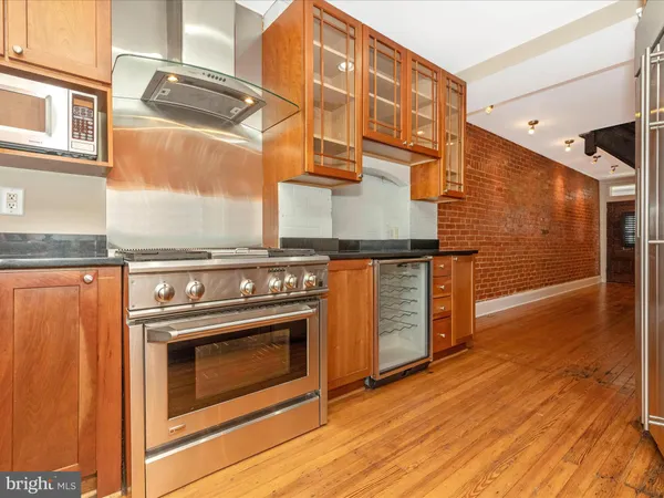 a kitchen with granite countertop wooden floors and stainless steel appliances
