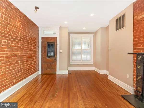 a view of an empty room with wooden floor