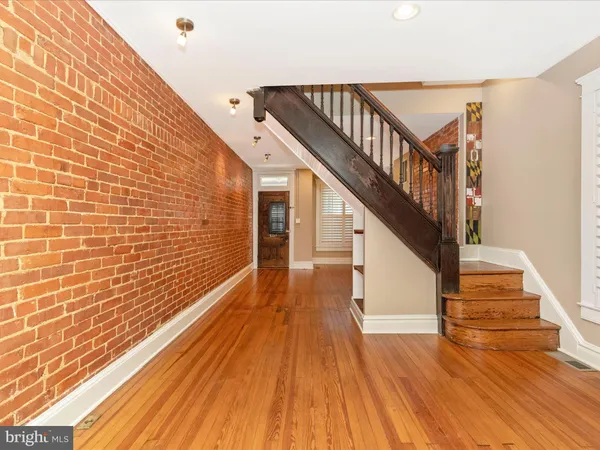 a view of a room with wooden floor and a bathroom