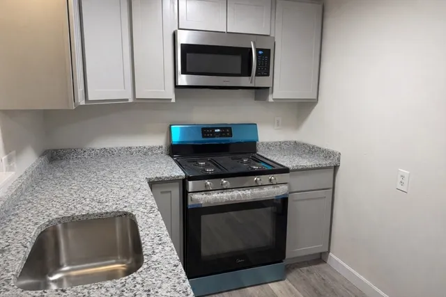 a kitchen with stainless steel appliances granite countertop white stove a microwave and oven