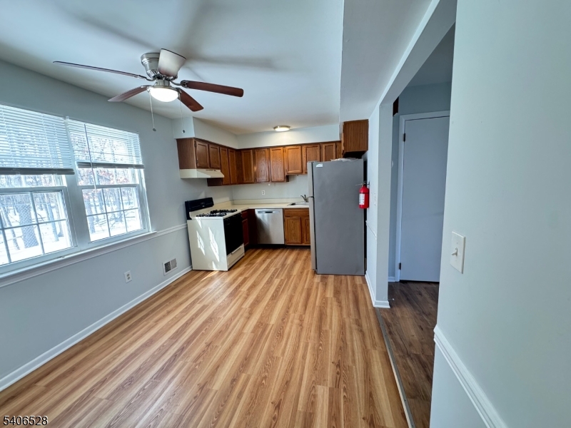 a view of a kitchen with wooden floor and windows