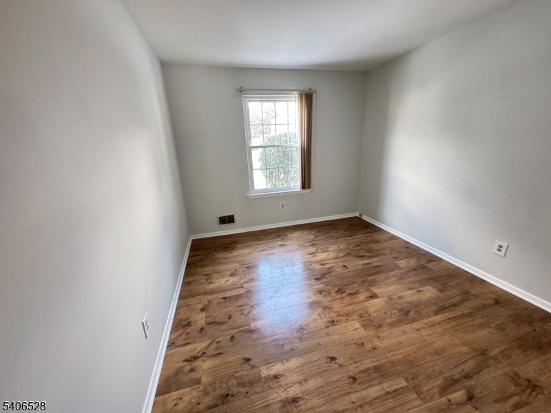 15 Hanover Square, Unit C Middlesex, NJ 08846 - Photo 8 of 12 an empty room with wooden floor and windows