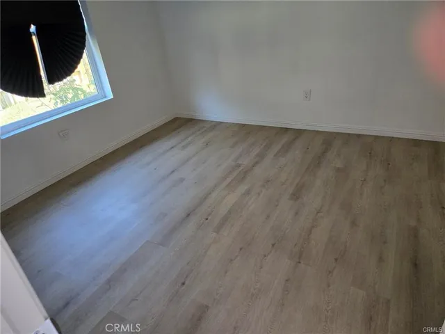 a view of an empty room and wooden floor