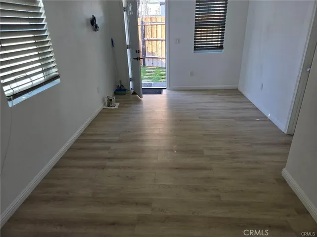 a view of a hallway with wooden floor and windows