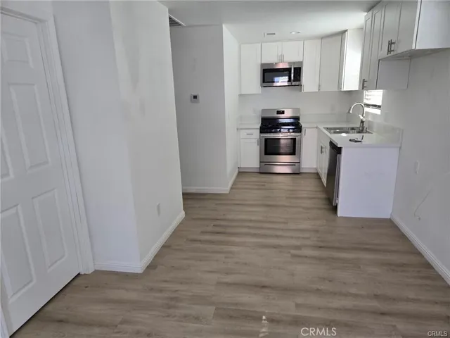 a kitchen with granite countertop a refrigerator and a stove top oven