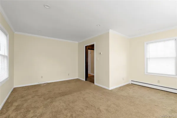 an empty room with a windows and cabinet