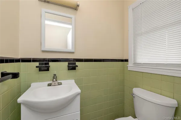 a bathroom with a sink a toilet and mirror